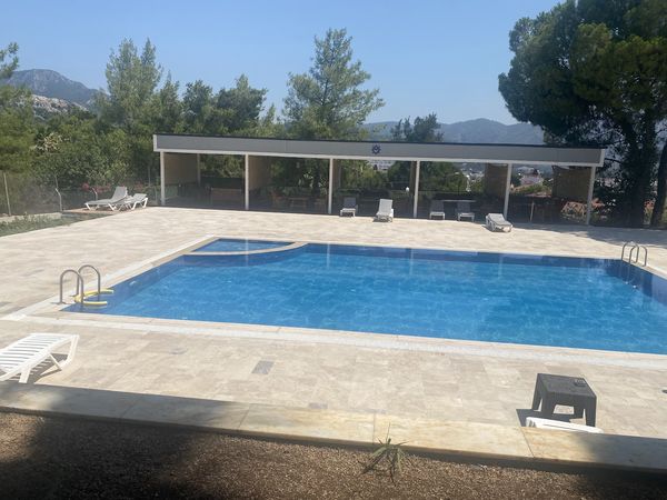 Armutalan Polis Evi'nin yüzme havuzu ve şezlonglar
