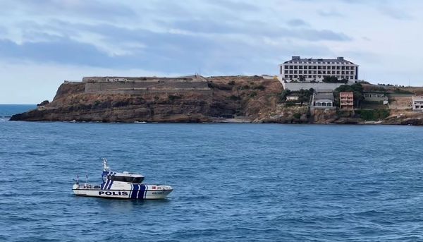 Riva Polis Evi'nin denizden görünümü; kıyıdaki tesis ve polis botu