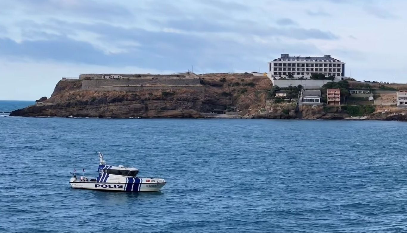 Riva Polis Evi'nin denizden görünümü; kıyıdaki tesis ve polis botu